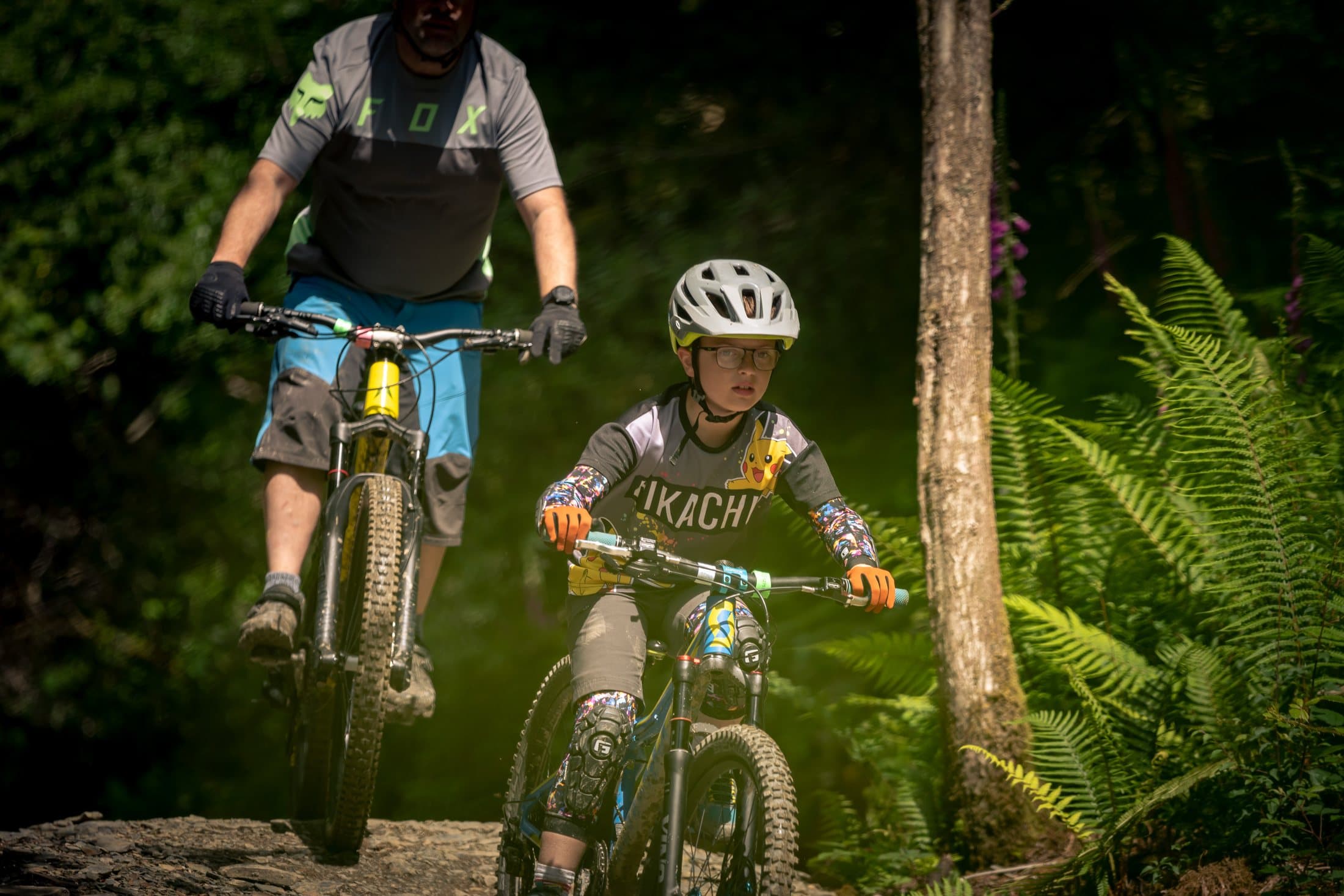 Adult and young rider riding a trail side by side