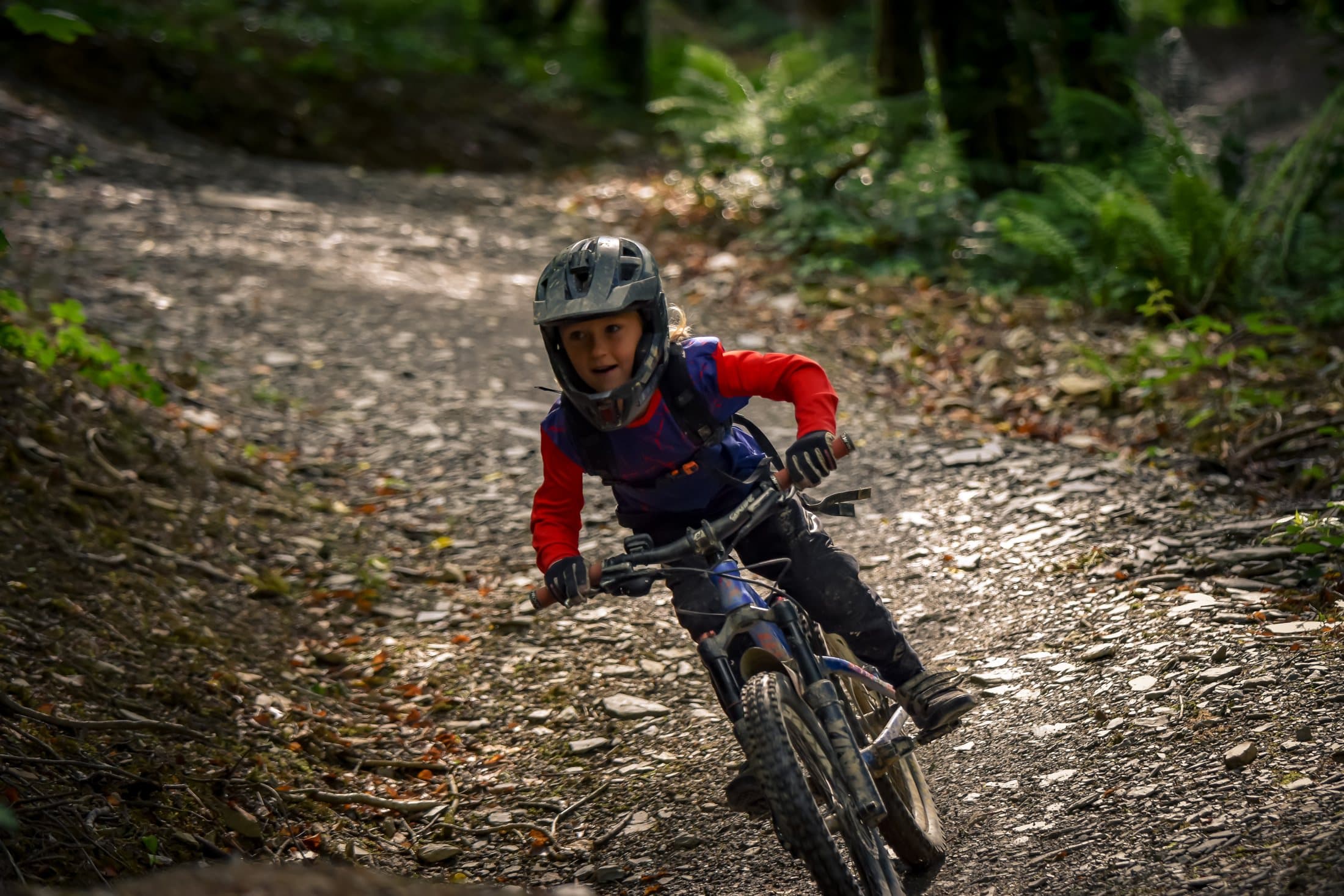 Rider in red jersey railing a loose dirt berm